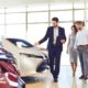 Couple and the dealer selling cars look the car in the showroom-US Auto Sales-ss-featured