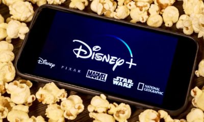 Disney Plus on smartphone with popcorn. Dinsey+ is a new streaming subscription service that will feature Marvel, Pixar, Star Wars, and National Geographic content-disney streaming-ss-featured