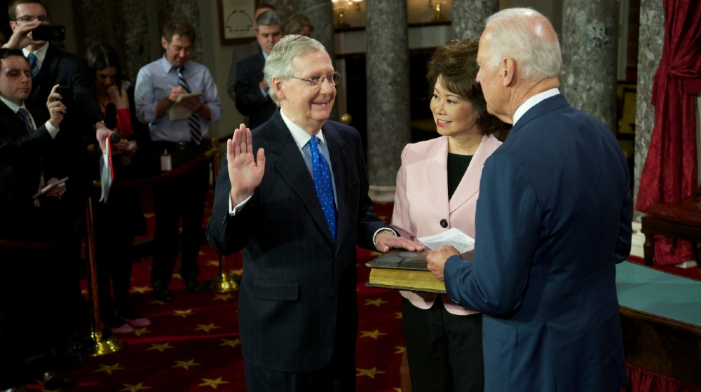 Senator Mitch McConnell with his wife Elaine Chao holding the bible is sworn in by Vice-President Joseph Biden-biden mcconnell together-ss-featured