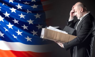 The dismissed employee clutched his head against the background of the US flag-Weekly Jobless Claims-ss-featured
