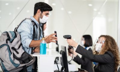 Male traveler shows phone to female officer at airline check in counter for issue airplane ticket boarding pass-Airline Travel Pass-ss-featured