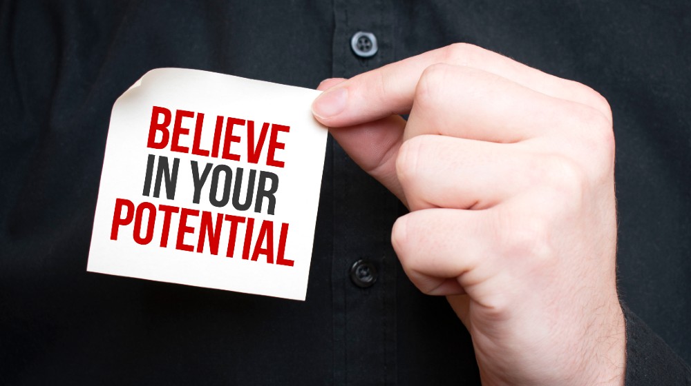Businessman holding a card with text Believe in your potential-ss-featured
