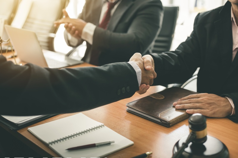 Businessman shaking hands to seal a deal with his partner lawyers or attorneys discussing a contract agreement-attorney-ss