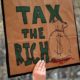 People carrying signs protesting President Trump at the Tax March in Manhattan in 2017 in New York City-Wealth Tax-ss-featured