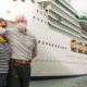 Senior Couple Wearing Face Masks Standing In Front of Passenger Cruise Ship-Cruise Lines Stock-ss-featured