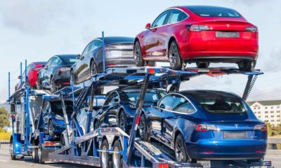 Car transporter carries Tesla Model 3 new vehicles on a freeway in San Francisco bay area-Tesla Stocks-ss-featured