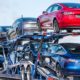 Car transporter carries Tesla Model 3 new vehicles on a freeway in San Francisco bay area-Tesla Stocks-ss-featured