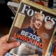 Forbes magazine with Jeff Bezos on the cover in a hand. Jeff Bezos is president of Amazon-Jeff Bezos-ss-featured