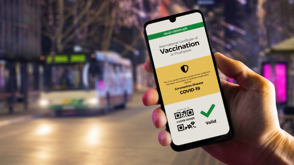 Smartphone displaying a valid digital vaccination certificate for COVID-19 in male's hand | WHO Against Vaccine Passports For International Travel | WHO Against Vaccine Passports For International Travel | Featured