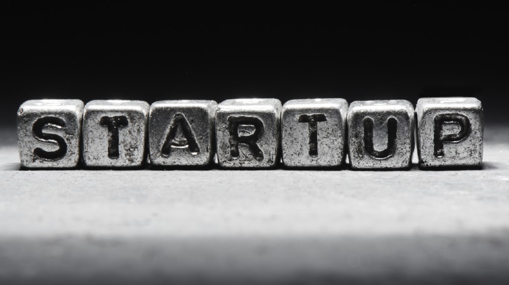 Inscription startup on metal cubes in grunge style on a black background isolated | Why the Startup Market Could Boom in 2021 | Featured