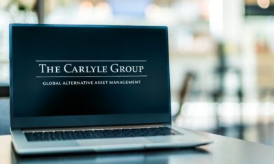 Laptop computer displaying logo of The Carlyle Group, an American multinational private equity, alternative asset management and financial services corporation | BCIM Corp Sells 869 Shares of The Carlyle Group Inc | Featured