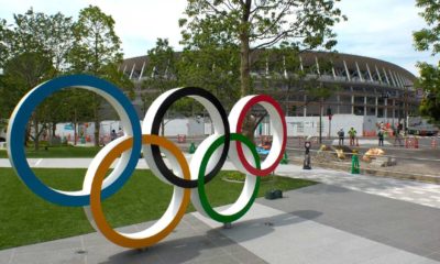 The five ring symbol of the Olympic Games and view of the New National Stadium under construction for Tokyo Olympic 2020 | US Issues Travel Warning to Japan Despite Tokyo Olympics | Featured