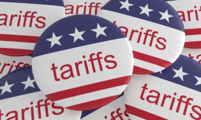 USA Politics News Badges Pile of Tariffs Buttons With US Flag | Businesses Blame Import Tariffs For Inflation | Featured