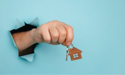 Man's hand with house keys through a hole in blue paper | Homeowner Equity Rises As Housing Prices Remain High | featured