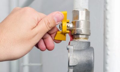 Person's hand opens or closes yellow gas valve on gas pipe at home | Democrats Want To Ban Natural Gas For Homes | Featured