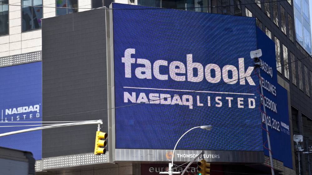 Sign announcing Facebook IPO is flashed on a screen outside the Thomson Reuters building | Facebook Hits $1 Trillion Cap As Antitrust Suits Dismissed | featured
