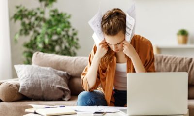 Young tired freelancer in casual clothes focusing on papers and searching for problem solution | Top 10 Startup Mistakes | featured