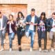 Friends group using smartphone against wall at university college backyard break | Tech firms in new battle for millennials | featured