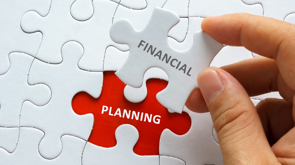 Hand holding piece of jigsaw puzzle with word FINANCIAL PLANNING | Why Financial Planning Is Important for Your Business? | featured