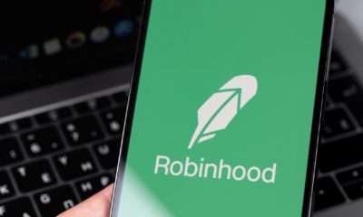 Robinhood mobile app on screen smartphone, iPhone in hand | Robinhood App To Pay $70 Million For Harming Customers | featured
