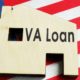 VA loan sign on the wooden home and American flag | Do You Qualify for a VA Loan? | featured