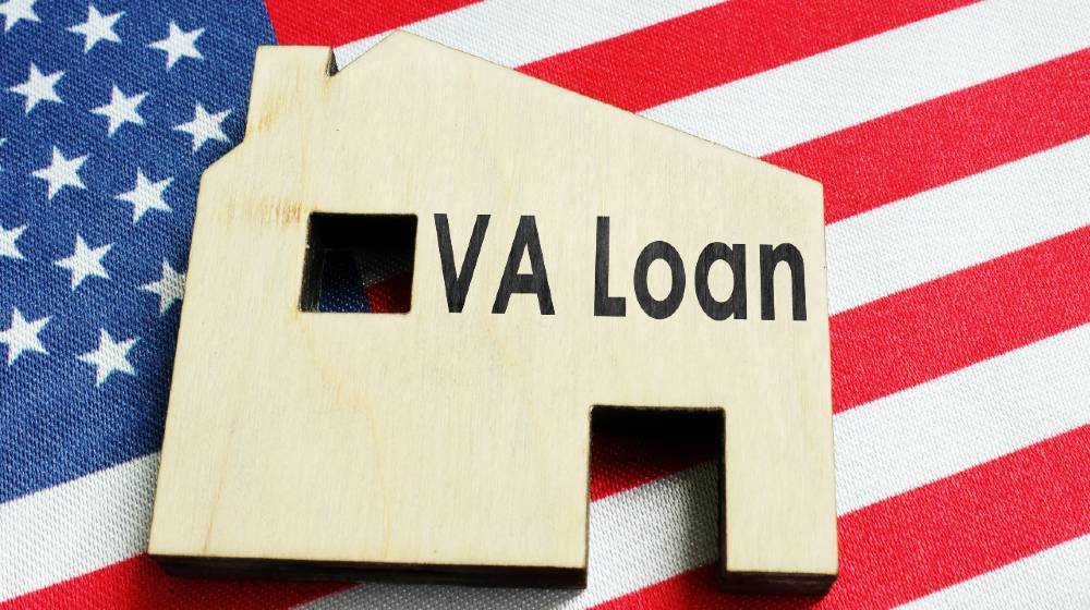 VA loan sign on the wooden home and American flag | Do You Qualify for a VA Loan? | featured