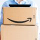 Vie from the front of happy smiling woman holding two large Amazon Prime cardboard | The Challenges Facing New Amazon CEO Andy Jassy | featured