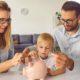 Little child puts money inside piggy bank, learns to effectively manage budget and spend wisely | Fun Ways to Teach Kids About Money | featured