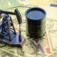 Petroleum, petrodollar and crude oil concept Pump jack and a black barrel on US USD dollar notes | Crude Prices Jump 6% Yesterday, Snaps 7-Day Losing Streak | featured