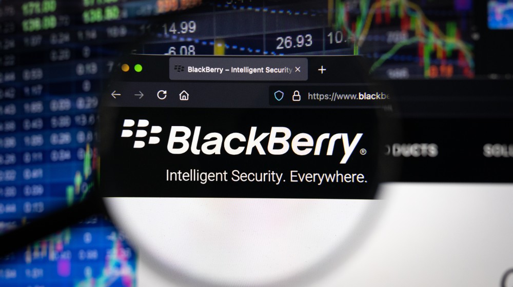 BlackBerry company logo on a website with blurry stock market developments in the background | TD Securities Raises BlackBerry Price Target to $9.00 | Featured