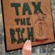 People carrying signs protesting President Trump at the Tax March in Manhattan | Senate Democrats Want Taxes on Stock Buybacks and CEO Pay | featured