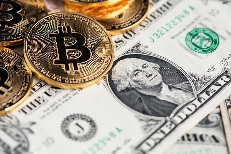 Background with Bitcoin cryptocurrency coins on one US Dollar-JPMorgan CEO