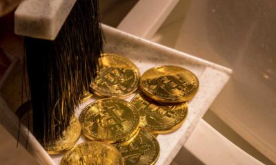 Brushing bitcoins into a dustpan as concept for the collapse in value of cyber coins and digital currency | JPMorgan CEO Says Bitcoin Worthless, Has No Intrinsic Value | featured