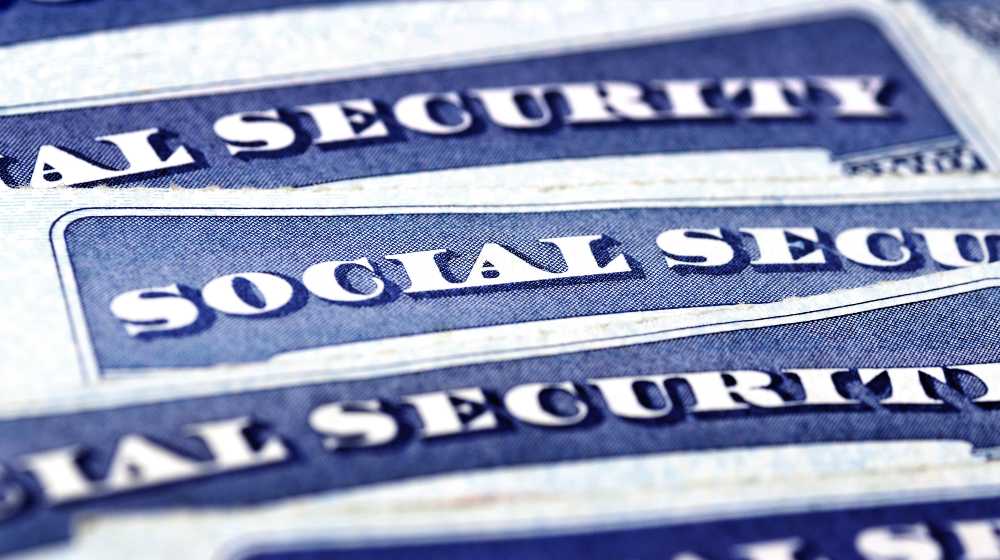 Closeup detail of several Social Security Cards representing finances and retirement | Social Security To Raise Benefits By 5.9% Starting Next Year | featured