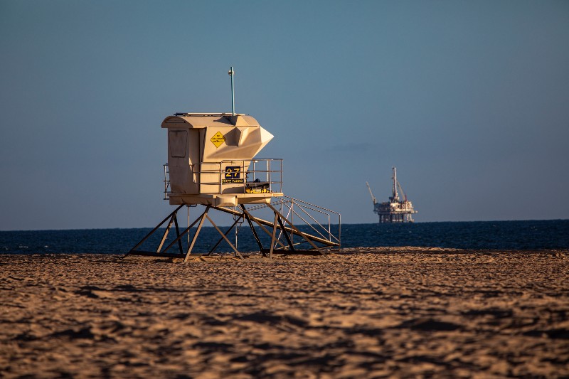 Lifeguard tower and offshore oil rig in late afternoon light in Huntington Beach Ca-California Oil Spill