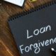 Loan forgiveness note on notepad black page | Troubled student loan forgiveness program gets an overhaul | featured