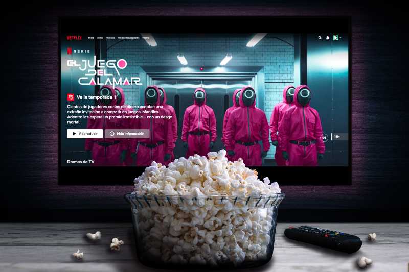 Netflix app on tv screen playing El Juego del calamar (Squid Game) behind a bowl of popcorn and a remote control-Squid Game