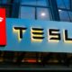 Tesla sign on the building on car sales | Tesla Joins $1 Trillion Dollar Market Cap Club | featured