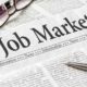 A newspaper with the headline Job Market | US Unemployment Claims Fall To Lowest Levels in 20 Months | featured