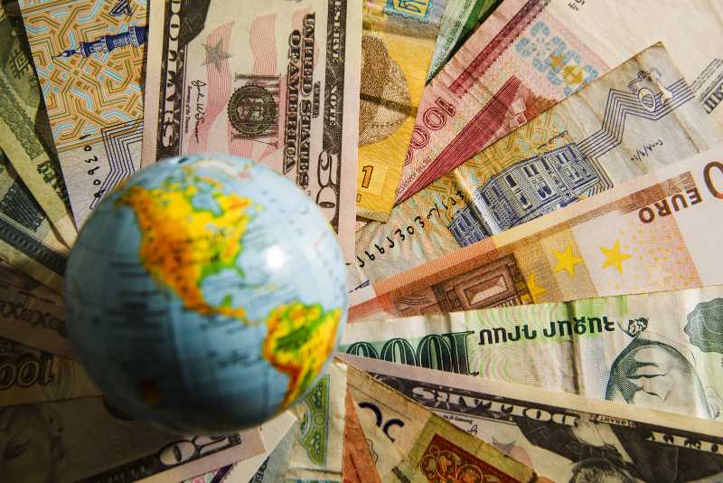 Globe map sign over many american dollar bank notes-Global Wealth