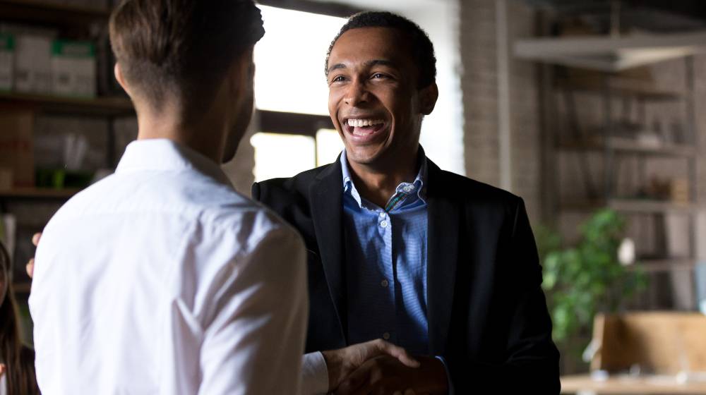 Happy black ceo handshaking rewarding successful worker | Why Leaders Must Earn The FAITH Of Their Stakeholders? | featured