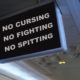 Humorous interior plane TV monitor message prohibiting passengers from rude and unruly behavior | Justice Department Will Charge Unruly Airline Passengers | featured