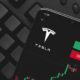 Logo Tesla on screen smartphone | Elon Musk Faces $15b Tax Bill as He Plans to Sell Tesla Stock | featured