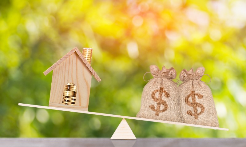house and money bag put on the balance scales Saving for buy a new home-US Household Debt