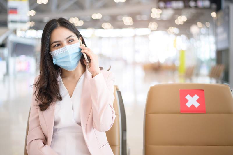 A business woman is wearing protective mask in International airport, travel under Covid-19 pandemic | International Travelers