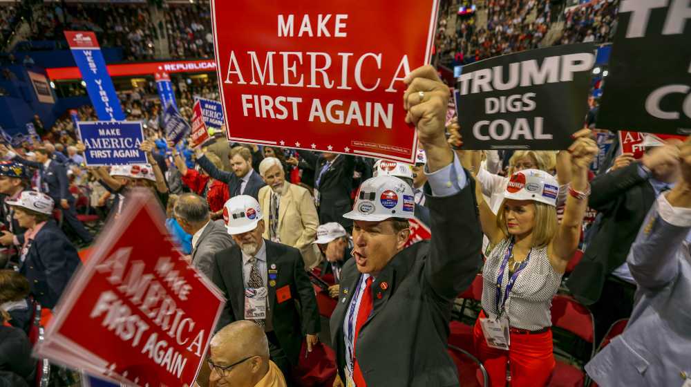 Delegates from West Virginia, hold up signs from the floor of the Quicken Arena | Coal Workers Union Ask Manchin To Reconsider BBB Decision | featured