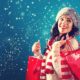 Happy young woman holding shopping bags in a snowy night | Despite Omicron, US Holiday Sales up by 8.5% This Year vs Last Year | featured