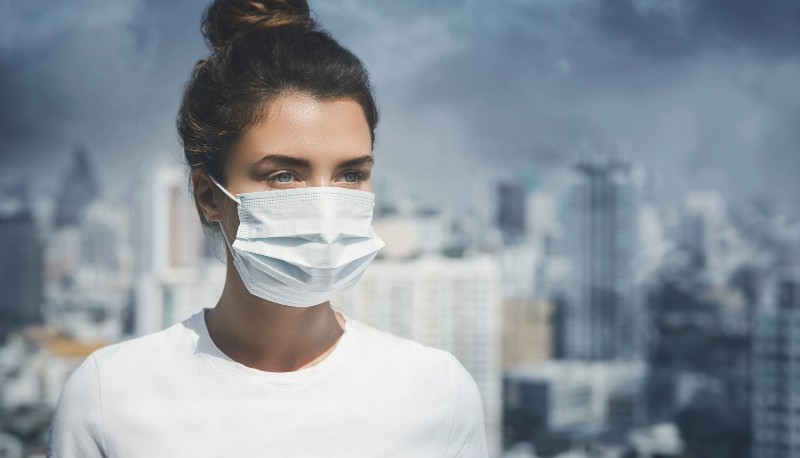 Woman wearing face mask because of air pollution in the city | Air Pollution