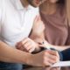 Close up of couple signing documents | American Home Buyers Rushing To Close Deals Before Mortgage Rates Go Higher | featured
