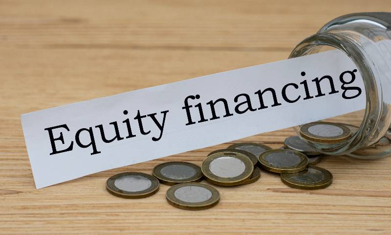 EQUITY FINANCING words on a white strip of paper with a can of money | Equity Investment
